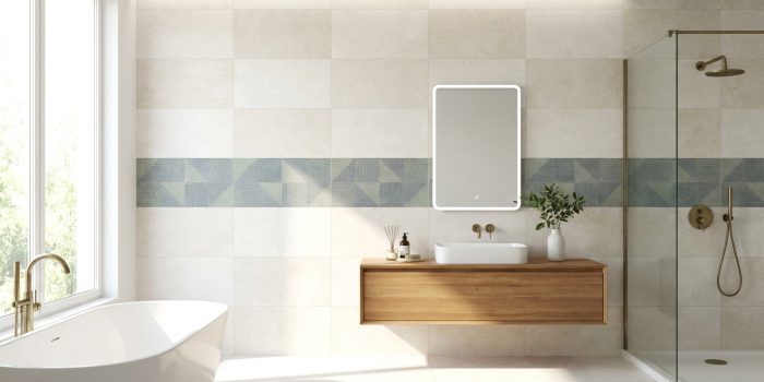 Salle de bain moderne lumineuse avec frise décorative en carrelage bleu-vert, baignoire, meuble-vasque en bois et douche à l'italienne.